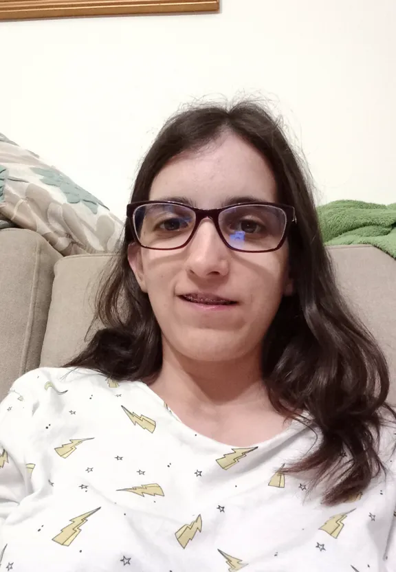 a woman wearing glasses sitting on a couch