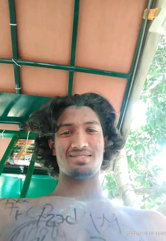 a man with curly hair standing in front of a building