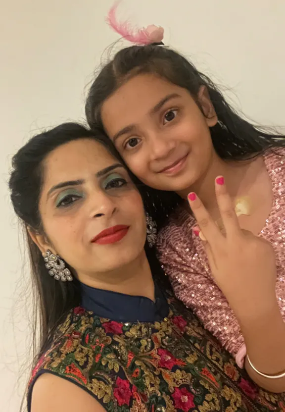 two girls pose for the camera with their hands on their shoulders