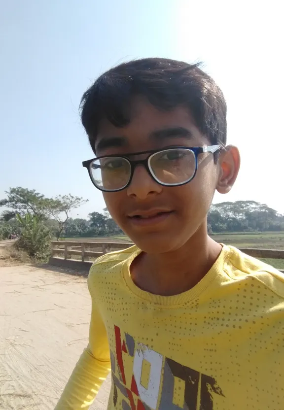 a young boy wearing glasses and a yellow shirt