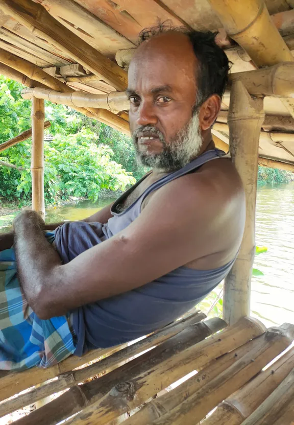 a man sitting on a wooden bench under a roof