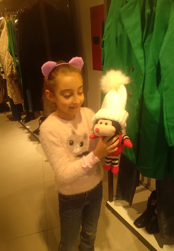 a young girl holding a stuffed animal toy