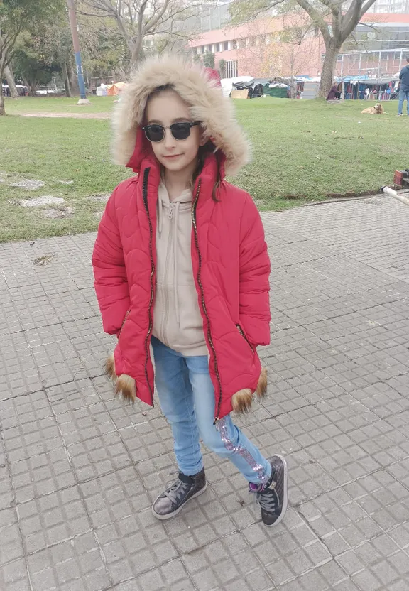 a little girl wearing a red jacket and sunglasses