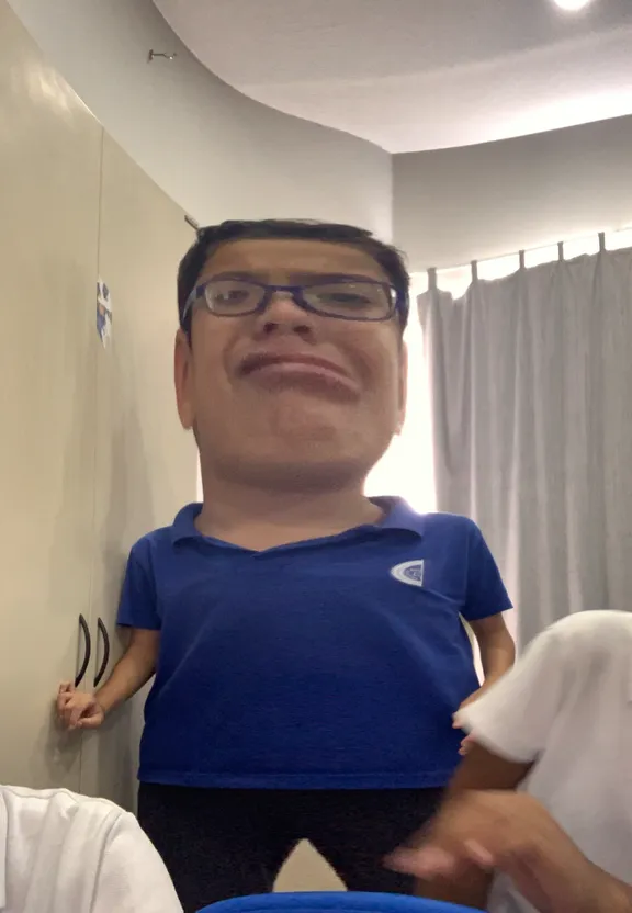 a man in a blue shirt standing in a bathroom