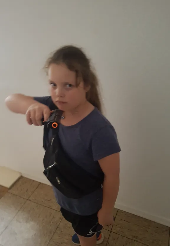 a little girl pointing a gun at the camera