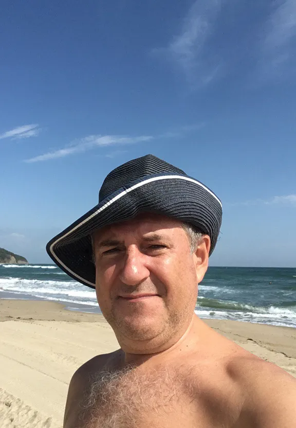a man wearing a hat standing on a beach