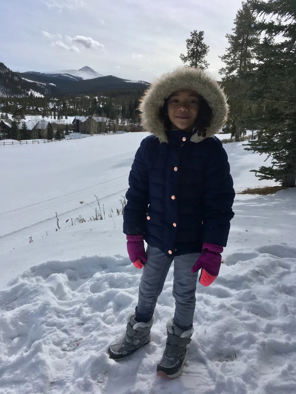 a little girl on a snowboard wearing cool snowboard gear