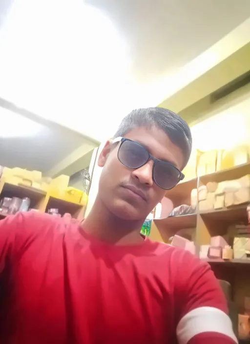 a man in a red shirt and sunglasses taking a selfie