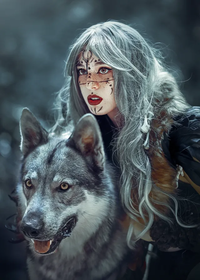 a woman with white hair and makeup is next to a wolf. dog, plant, eye, carnivore, flash photography, fawn, art, tree, companion dog, wolf