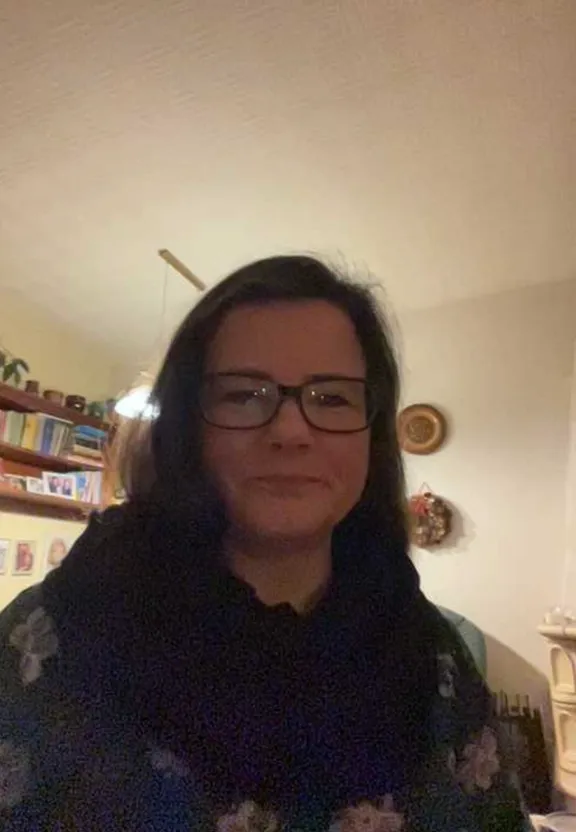 a woman wearing glasses and a scarf in a living room