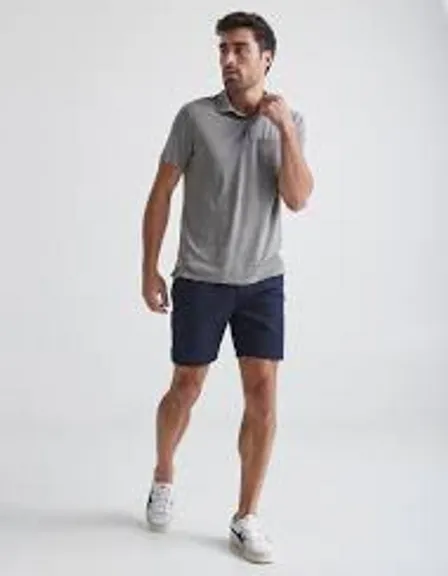 a man in a gray shirt and blue shorts