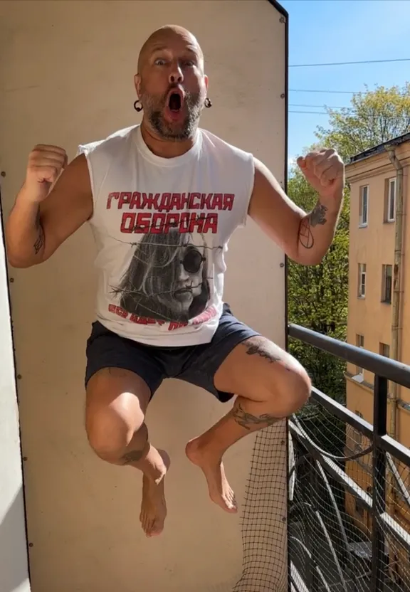 a man is jumping in the air on a balcony