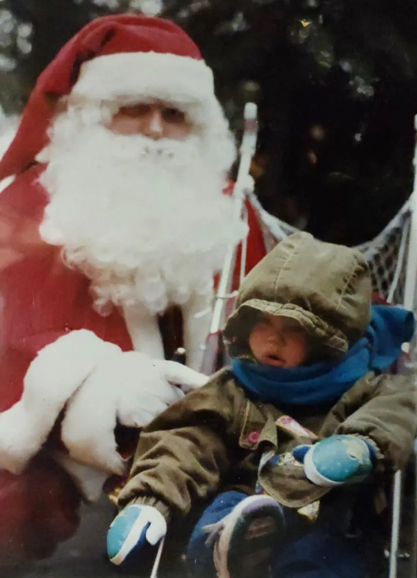 a young child sitting in front of a santa clause