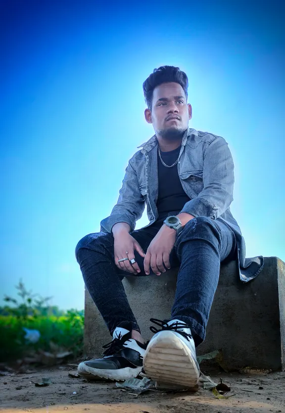 a man sitting on top of a cement block