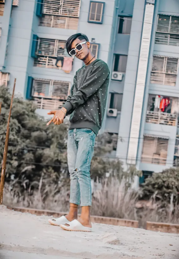 a man wearing sunglasses and a hat standing in front of a building