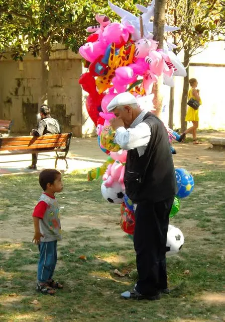 a man standing next to a little boy in a park