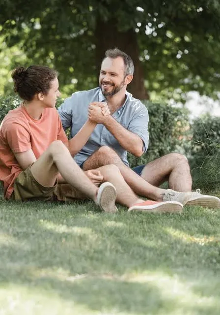 a man and a woman sitting on the grass