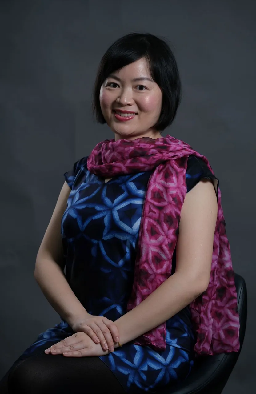 a woman sitting in a chair with a pink scarf around her neck