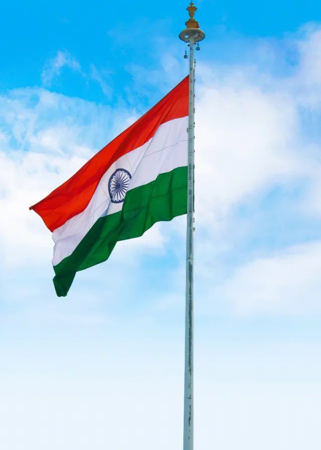 the indian flag is flying high in the sky. cloud, sky, flag, cumulus, wind, pole, event, symbol