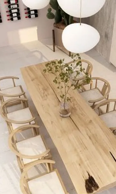 a wooden table surrounded by chairs and a vase of flowers