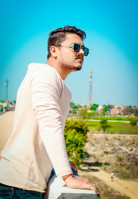 a man wearing sunglasses leaning on a wall