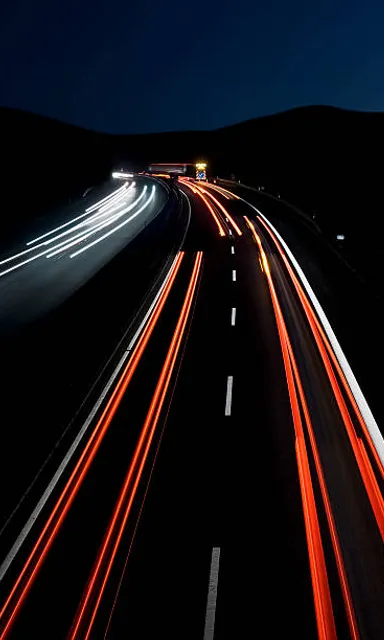a long exposure photo of a highway at night