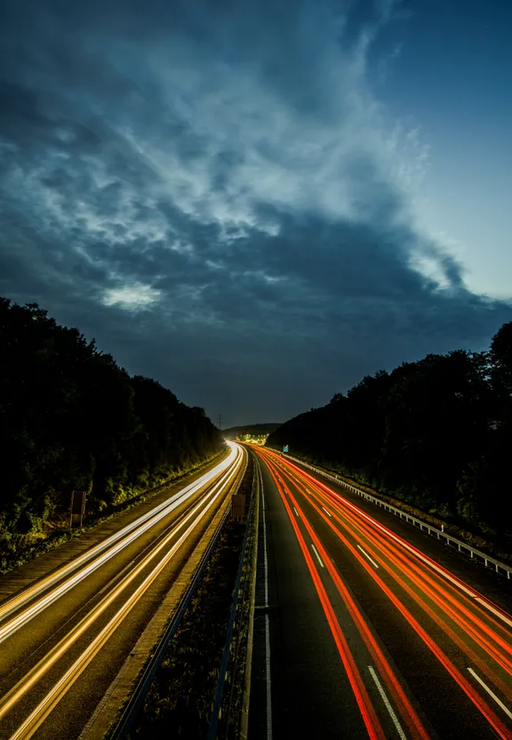 a long exposure photo of a highway at night