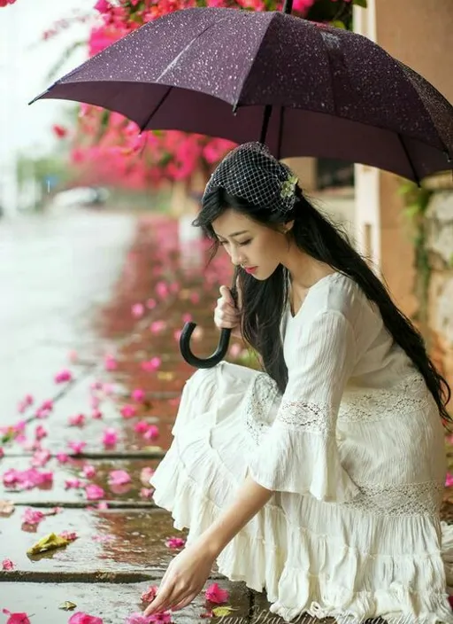 Umbrella Woman Sitting on Ground, It's Raining!. She's wearing a raincoat, so it must be raining!