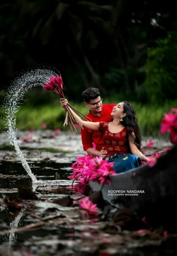 a man and a woman in a boat with flowers