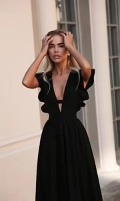 a woman in a black dress is posing for a picture