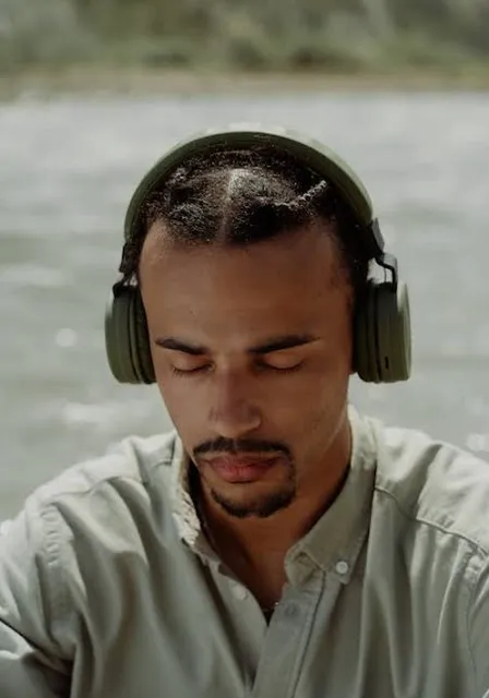 a man wearing headphones next to a river