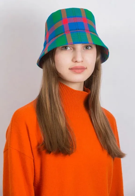 a woman wearing an orange sweater and a plaid hat