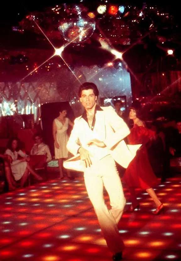 a man in a white suit on a dance floor