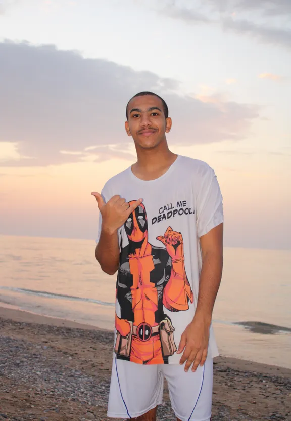 a man standing on a beach giving the peace sign