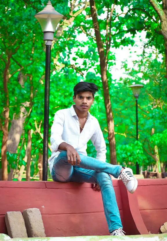 a man sitting on a bench in a park