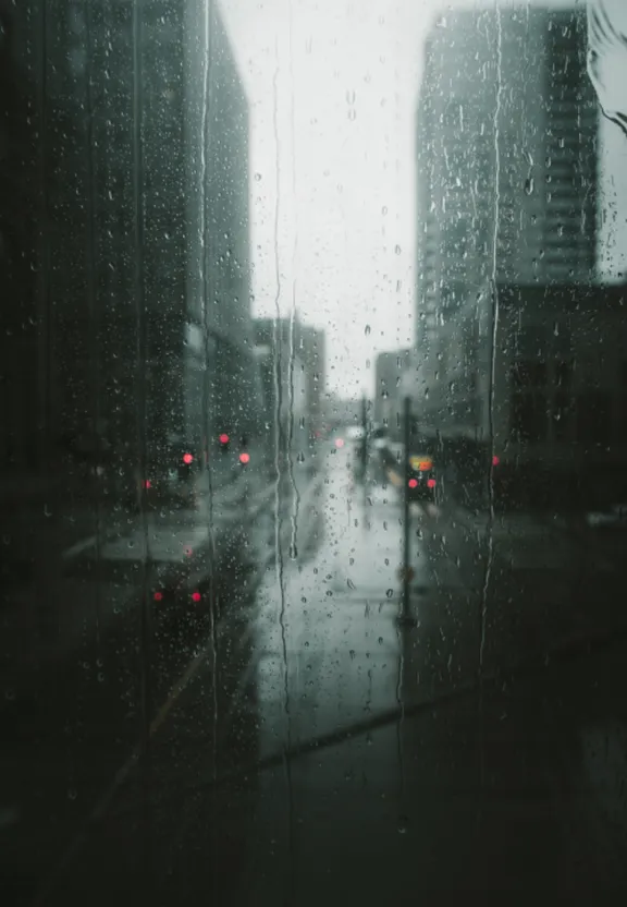 a view of a city street through a rain covered window