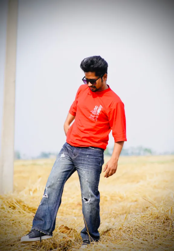 A man in a blue shirt stands in a blue sky. Replace the background with a blue sky