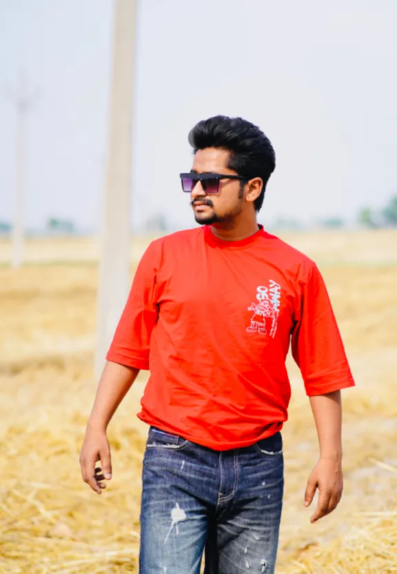 a man in a red shirt standing in a field