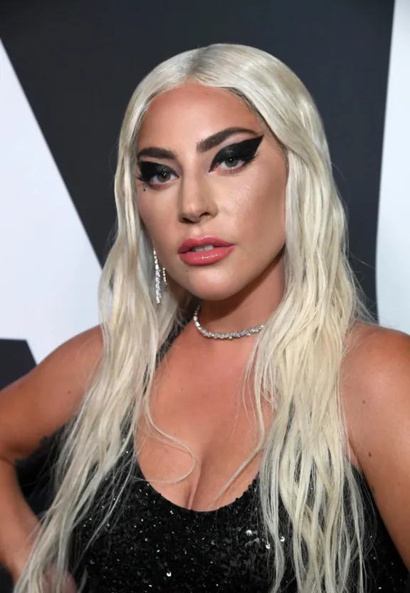 a woman with long white hair wearing a black dress