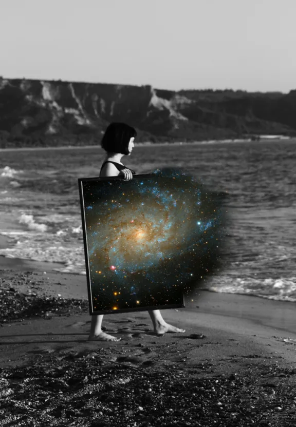 a woman holding a picture of a spiral galaxy