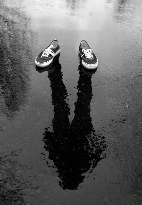 a pair of shoes sitting on top of a puddle