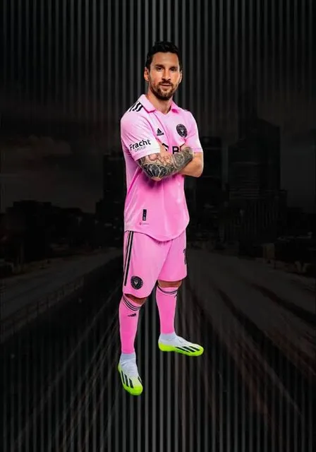 a man in a pink soccer uniform standing with his arms crossed