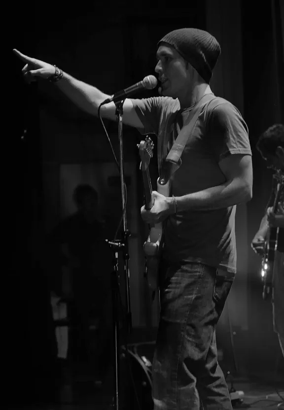 a man standing in front of a microphone on a stage