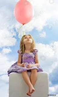 a little girl sitting on top of a white block