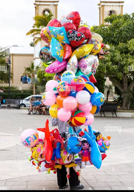 a person holding a bunch of balloons in front of a building