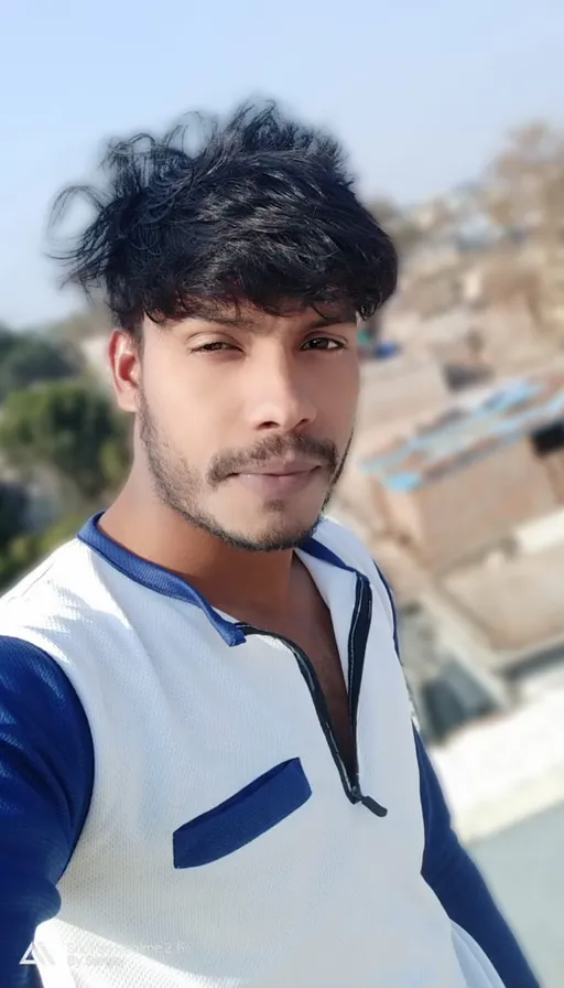 a man with black hair wearing a white and blue shirt