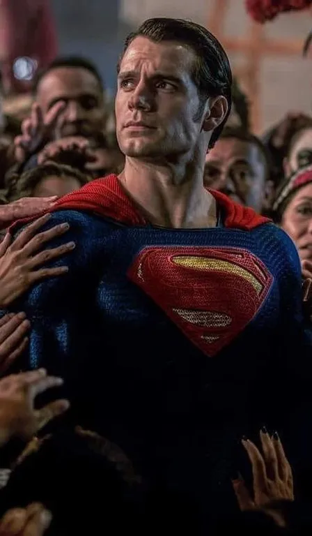 a man in a superman suit surrounded by people