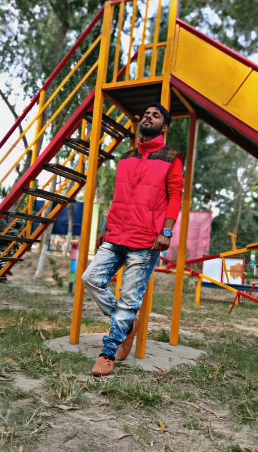 a man standing in front of a yellow and red playground structure