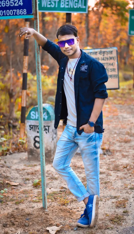 a man standing next to a street sign