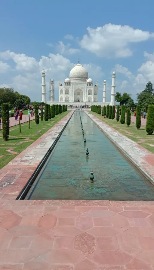 a large white building with a long pool of water in front of it